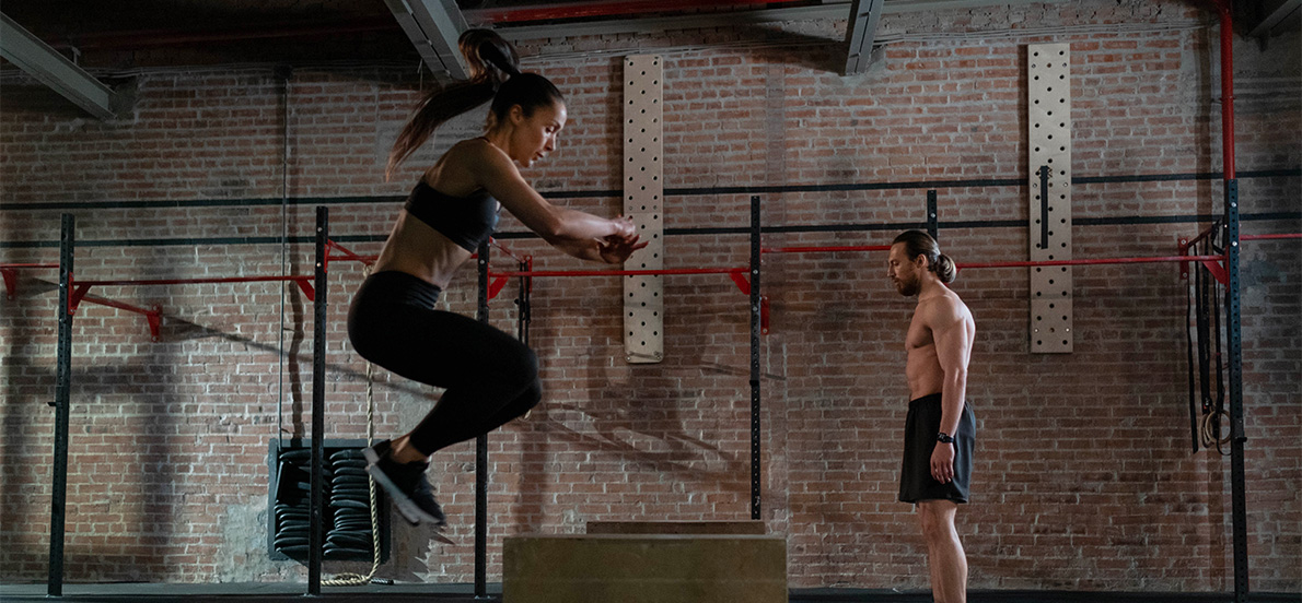 Dans la salle de Crossfit Kasadenn, une femme et un homme sautent sur des box